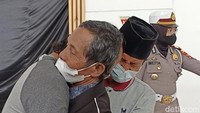 Kakek Muhadi dan dua anaknya berpelukan/Foto: Adhar Muttaqin/detikJatim