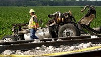Seorang pekerja melihat truk sampah yang bertabrakan dengan kereta Amtrak yang menyebabkan sejumlah gerbong kereta tergelincir.