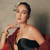 Kain ulos berwarna merah tampak dipadukan dengan bustier hitam dan aksesori seperti anting, kalung, gelang, dan hiasan kepala berwarna keemasan. Foto: Instagram/@lunamaya