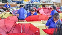 Sejumlah pekerja memasang bahan yang sudah dijahit pada rangka payung. Yuan He/Feature China/Future Publishing via Getty Images