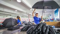 Sejumlah karyawan memeriksa kembali payung yang telah diuji coba untuk selanjutnya dikemas dan didistribusikan. Yuan He/Feature China/Future Publishing via Getty Images