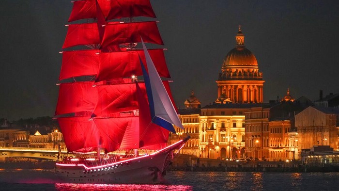 People watch fireworks and a brig with scarlet sails sailing on the Neva River during the Scarlet Sails festivities marking school graduation in St. Petersburg, Russia, early Saturday, June 25, 2022. (AP Photo/Dmitri Lovetsky)