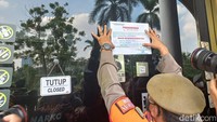 Petugas memasang stiker segel di pintu masuk Holywings Reserve Senayan. Petugas juga meminta tanda tangan dari manajemen Holywings Reserve Senayan terkait upaya penindakan yang dilakukan (Tim detikcom/detikcom)