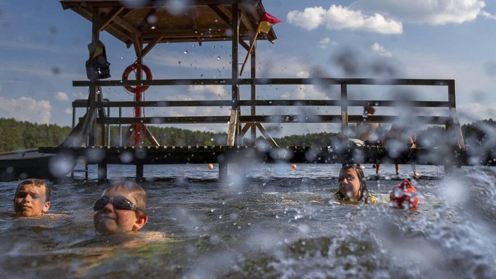 Segarnya Nyebur ke Danau Saat Lithuania Lagi Panas-panasnya People enjoy the warm weather in the lake near Vilnius, Lithuania, Monday, June 27, 2022. The heat wave continues in Lithuania as temperatures rise to as high as 32 degrees Celsius (89.6 degrees Fahrenheit). (AP Photo/Mindaugas Kulbis)