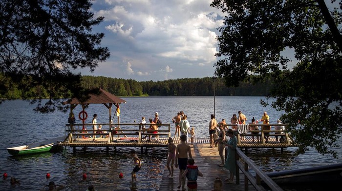 Segarnya Nyebur ke Danau Saat Lithuania Lagi Panas-panasnya People enjoy the warm weather in the lake near Vilnius, Lithuania, Monday, June 27, 2022. The heat wave continues in Lithuania as temperatures rise to as high as 32 degrees Celsius (89.6 degrees Fahrenheit). (AP Photo/Mindaugas Kulbis)