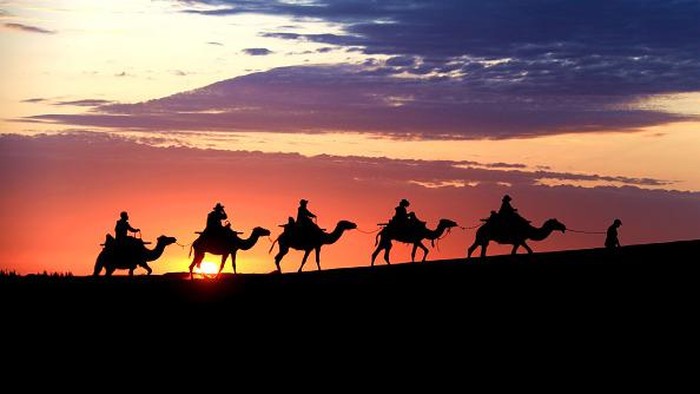 DUNHUANG, CHINA - JUNE 27: Tourists ride camels at the Mingsha Mountain and Crescent Spring scenic spot on June 27, 2022 in Dunhuang, Gansu Province of China. (Photo by Zhang Xiaoliang/VCG via Getty Images)