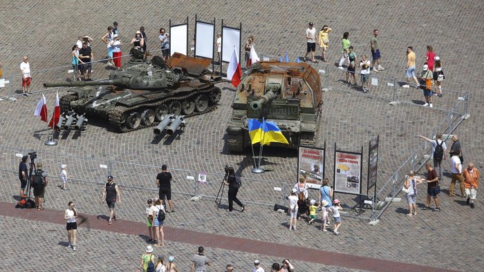 Tank-tank Rusia yang Rusak Dipamerkan di Polandia People visit an open-air exhibition of damaged and burnt-out Russian tanks and armored vehicles at the Castle Square, in Warsaw, Poland, Monday, June 27, 2022. The vehicles were captured by Ukrainian military forces during the war in the Ukraine. Ukrainian authorities announced that there are plans for similar exhibits in other European capitals such as Berlin, Paris, Madrid and Lisbon. (AP Photo/Michal Dyjuk)
