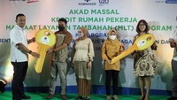 Direktur Keuangan BP Jamsostek Asep Rahmat Suwandha bersama dengan Direktur Assets Management Bank BTN Elisabeth Novie Riswanti menyerahkan simbolis kunci rumah kepada pekerja yang mendapatkan Manfaat Layanan Tambahan (MLT) dari program Jaminan Hari Tua (JHT).