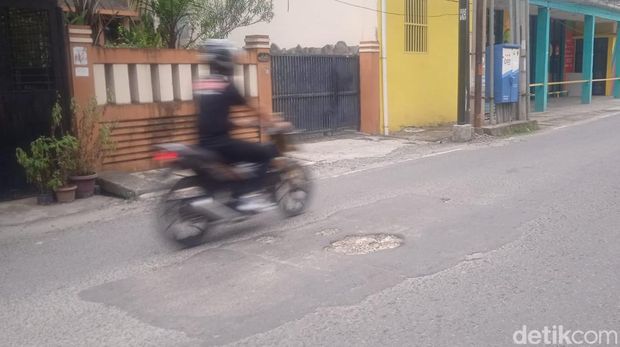 Kendaraan menghindari lubang yang ada di Jalan Mayang, Kecamatan Medan Petisah.