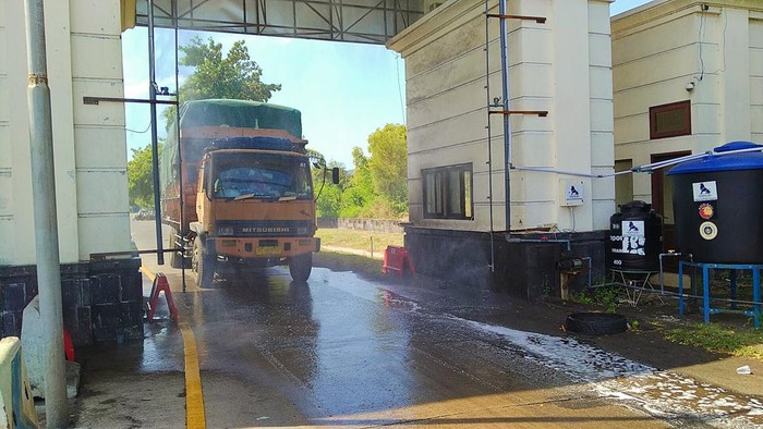 Kendaraan barang yang masuk Bali disemprot disinfektan secara otomatis di Pelabuhan Gilimanuk, Jembrana, Bali, Selasa (28/6/2022).