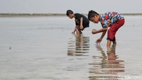 Terlihat anak-anak asyik bermain air saat berwisata ke Pantai Tidung.