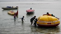 Ada pula pengunjung yang asyik berenang maupun bermain di wahana air yang tersedia di pantai tersebut.