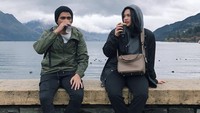 Alyssa duduk santai di pinggir danau bersama kakak laki-lakinya, Adrian. Momen ini makin lengkap dengan menyeruput kopi panas. Foto: Instagram @dollyssa