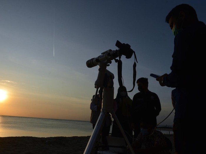 Petugas mengamati posisi hilal menggunakan teropong saat pelaksanaan Rukyatul Hilal di Pantai Jerman, Kuta, Badung, Bali, Rabu (29/6/2022). Pengamatan posisi bulan yang dilakukan untuk menentukan awal bulan Zulhijah dan Idul Adha 1443 H/2022 M di pantai tersebut tidak berhasil melihat hilal karena kondisi cuaca berawan serta ketinggian hilal yang masih terlalu rendah. ANTARA FOTO/Fikri Yusuf/wsj.