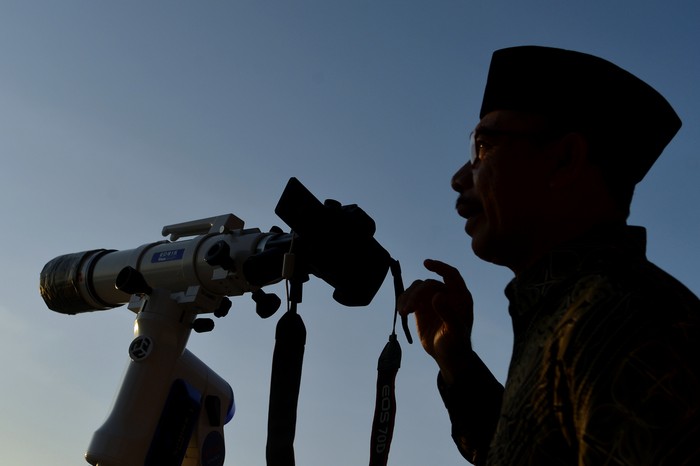 Petugas mengamati posisi hilal menggunakan teropong saat pelaksanaan Rukyatul Hilal di Pantai Jerman, Kuta, Badung, Bali, Rabu (29/6/2022). Pengamatan posisi bulan yang dilakukan untuk menentukan awal bulan Zulhijah dan Idul Adha 1443 H/2022 M di pantai tersebut tidak berhasil melihat hilal karena kondisi cuaca berawan serta ketinggian hilal yang masih terlalu rendah. ANTARA FOTO/Fikri Yusuf/wsj.