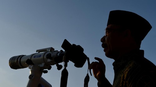 Petugas mengamati posisi hilal menggunakan teropong saat pelaksanaan Rukyatul Hilal di Pantai Jerman, Kuta, Badung, Bali, Rabu (29/6/2022). Pengamatan posisi bulan yang dilakukan untuk menentukan awal bulan Zulhijah dan Idul Adha 1443 H/2022 M di pantai tersebut tidak berhasil melihat hilal karena kondisi cuaca berawan serta ketinggian hilal yang masih terlalu rendah. ANTARA FOTO/Fikri Yusuf/wsj.