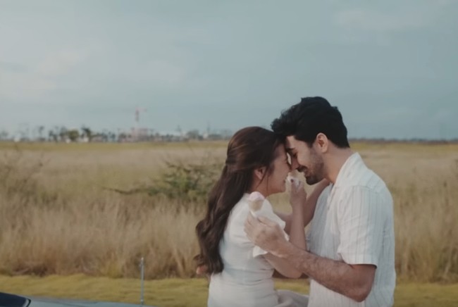 Prilly Latuconsina menggandeng Reza Rahadian untuk jadi pasangannya di video klip ‘Dear Love’. Keduanya mengenakan busana senada nuansa putih dan beige. Foto: Tangkapan Layar YouTube Prilly Latuconsina
