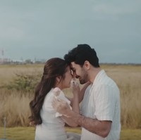 Prilly Latuconsina menggandeng Reza Rahadian untuk jadi pasangannya di video klip ‘Dear Love’. Keduanya mengenakan busana senada nuansa putih dan beige. Foto: Tangkapan Layar YouTube Prilly Latuconsina