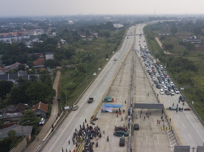 Polisi melakukan persuasi kepada sejumlah warga yang melakukan pemblokiran Tol Cimanggis-Cibitung saat berunjuk rasa di Jatikarya, Bekasi, Jawa Barat, Rabu (29/6/2022). Mereka menuntut Badan Pertahanan Nasional segera memberikan surat pengantar  untuk menyelesaikan pembayaran uang konsinyasi atas penggunaan tanah untuk Tol Cimanggis-Cibitung di daerah Jatikarya seluas 4,2 hektare yang belum dibayar selama 25 tahun. ANTARA FOTO/Fakhri Hermansyah/wsj.