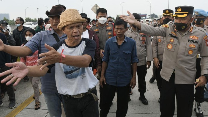 WARGA BLOKIR JALAN TOL CIMANGGIS-CIBITUNG DI JATIKARYA Polisi melakukan persuasi kepada sejumlah warga yang melakukan pemblokiran Tol Cimanggis-Cibitung saat berunjuk rasa di Jatikarya, Bekasi, Jawa Barat, Rabu (29/6/2022). Mereka menuntut Badan Pertahanan Nasional segera memberikan surat pengantar untuk menyelesaikan pembayaran uang konsinyasi atas penggunaan tanah untuk Tol Cimanggis-Cibitung di daerah Jatikarya seluas 4,2 hektare yang belum dibayar selama 25 tahun. ANTARA FOTO/Fakhri Hermansyah/wsj.