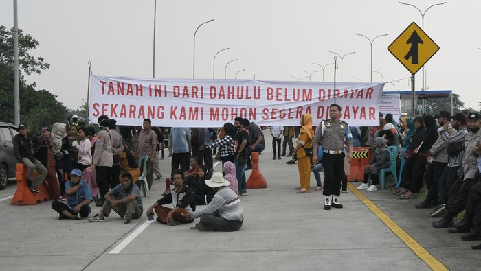 Polisi melakukan persuasi kepada sejumlah warga yang melakukan pemblokiran Tol Cimanggis-Cibitung saat berunjuk rasa di Jatikarya, Bekasi, Jawa Barat, Rabu (29/6/2022). Mereka menuntut Badan Pertahanan Nasional segera memberikan surat pengantar  untuk menyelesaikan pembayaran uang konsinyasi atas penggunaan tanah untuk Tol Cimanggis-Cibitung di daerah Jatikarya seluas 4,2 hektare yang belum dibayar selama 25 tahun. ANTARA FOTO/Fakhri Hermansyah/wsj.