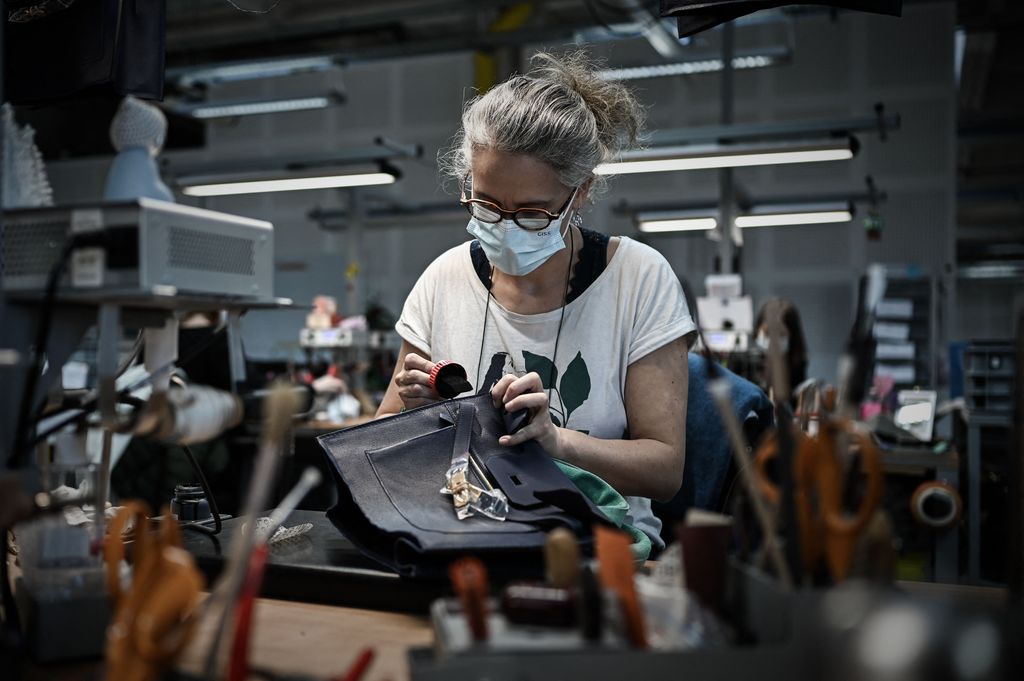 This picture taken on January 6, 2022 shows an employee working on a leather handbag at the leather goods workshop of French high fashion luxury goods manufacturer Hermes in Montbron some 28 kms East of Angouleme. (Photo by Philippe LOPEZ / AFP) (Photo by PHILIPPE LOPEZ/AFP via Getty Images)