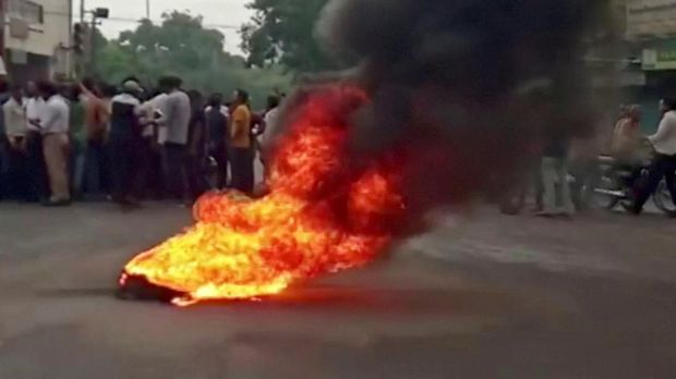 Asap mengepul dari bahan yang terbakar sementara orang-orang berkumpul di jalan saat ketegangan meningkat setelah pembunuhan seorang pria Hindu, di Udaipur, Rajasthan, India 28 Juni 2022. (ANI via REUTERS/HANDOUT)