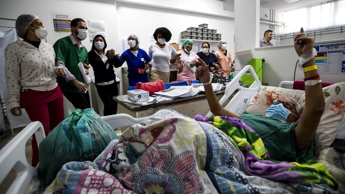 Patient Angelo Saior, right, gestures as he watches the performance of the clown group of the Nonprofit Organization Doctors of Joy at the Adão Pereira Nunes hospital in Duque de Caxias, Brazil, Wednesday, June 29, 2022. The group that performs in different hospitals using laughter to help in the recovery of hospitalized patients and their families, resumed activities in recent months after two years away due to the COVID-19 pandemic. (AP Photo/Bruna Prado)