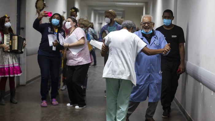 Patient Angelo Saior, right, gestures as he watches the performance of the clown group of the Nonprofit Organization Doctors of Joy at the Adão Pereira Nunes hospital in Duque de Caxias, Brazil, Wednesday, June 29, 2022. The group that performs in different hospitals using laughter to help in the recovery of hospitalized patients and their families, resumed activities in recent months after two years away due to the COVID-19 pandemic. (AP Photo/Bruna Prado)