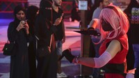 Seorang warga memotret pengunjung lain yang mengenakan kostum karakter anime Jepang saat Jeddah Season yang digelar di City Walk, Jeddah, Arab Saudi, Kamis (30/6/2022).