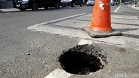 Penampakan jalan berlubang yang berada di salah satu sisi Jalan Gunawarman, Jakarta Selatan.