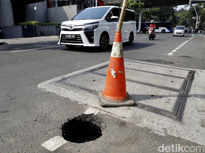 Lubang terlihat di salah satu sisi Jalan Gunawarman, Jakarta Selatan. Traffic cone dipasang sebagai penanda jalan berlubang bagi para pengendara yang melintas.