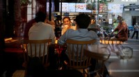 Tampak sejumlah orang menyantap makanan di sebuah restoran yang kembali mengizinkan pengunjung untuk makan di tempat di Shanghai, China.