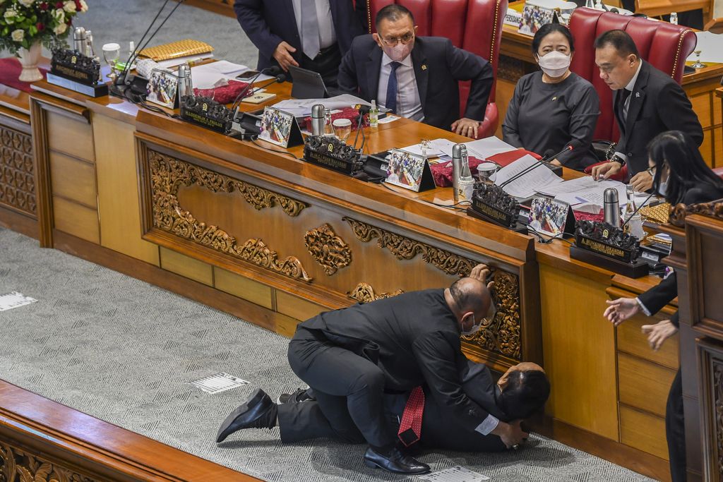 Momen Wakil Ketua Banggar DPR Terjatuh Saat Rapat Paripurna Wakil Ketua Badan Anggaran (Banggar) DPR Muhidin Muhammad Said (kedua kiri) dibantu staf sekjen saat terjatuh usai memberikan laporan hasil pembahasan RAPBN 2023 kepada pimpinan di Rapat Paripurna ke-26 Masa Persidangan V Tahun Sidang 2021-2022 di Gedung Nusantara III, Kompleks Parlemen, Senayan, Jakarta, Kamis (30/6/2022). ANTARA FOTO/Galih Pradipta/hp.