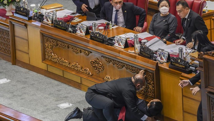 Momen Wakil Ketua Banggar DPR Terjatuh Saat Rapat Paripurna Wakil Ketua Badan Anggaran (Banggar) DPR Muhidin Muhammad Said (kedua kiri) dibantu staf sekjen saat terjatuh usai memberikan laporan hasil pembahasan RAPBN 2023 kepada pimpinan di Rapat Paripurna ke-26 Masa Persidangan V Tahun Sidang 2021-2022Â di Gedung Nusantara III, Kompleks Parlemen, Senayan, Jakarta, Kamis (30/6/2022). ANTARA FOTO/Galih Pradipta/hp.