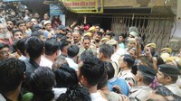 Kerumunan berkumpul di luar toko penjahit yang terbunuh, saat polisi menyelidiki di Udaipur, India, Selasa, (28/6/2022). Polisi menangkap dua pria Muslim yang dituduh membunuh seorang penjahit Hindu dalam dugaan serangan agama.