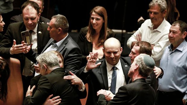 Politisi Israel mengucapkan selamat kepada Menteri Luar Negeri Israel Yair Lapid (kiri) dan Perdana Menteri Naftali Bennett yang akan keluar, menyusul pembubaran parlemen, di Yerusalem pada 30 Juni 2022. (AFP via Getty Images/MENAHEM KAHANA)