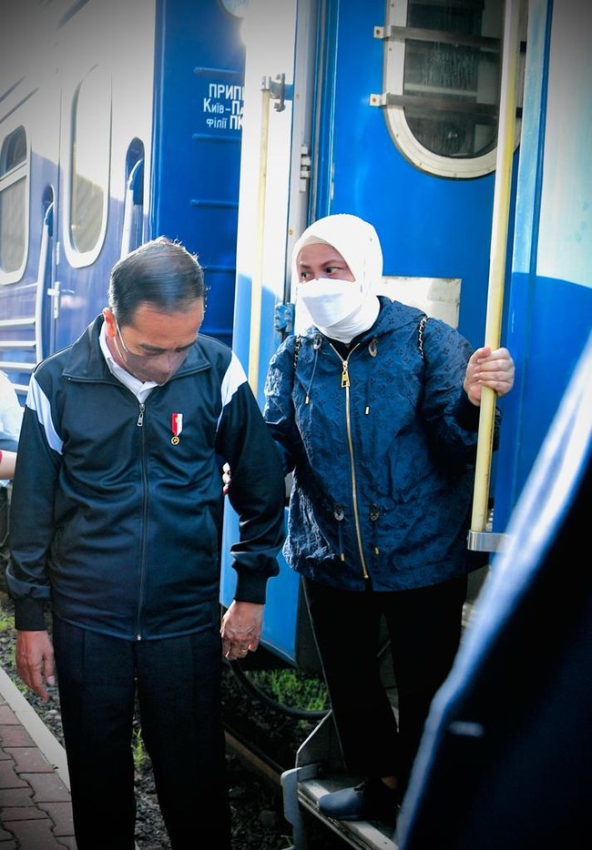 Jokowi dan Iriana tampil matching serba biru-hitam dan putih selama kunjungan ke Ukraina. Iriana Jokowi tampak memasukkan hijab putihnya ke dalam jaket sehingga penampilannya tampak lebih simpel. Foto: Biro Pers Sekretariat Presiden
