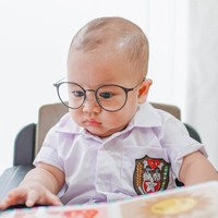 Sambil memakai kaca mata, Rayyanza tampak begitu serius melihat buku yang sedang dipegangnya. Gimana nih, sudah cocok jadi murid SD belum nih? Foto: Instagram/@raffinagita1717