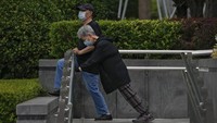 Warga mengenakan masker saat berolah raga di luar gedung perkantran komersial di Beijing. (AP News)