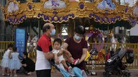 Sementara, warga lansia ini pun juga mengenakan masker di dekat wahana carousel di sebuah mal Beijing. (AP News)