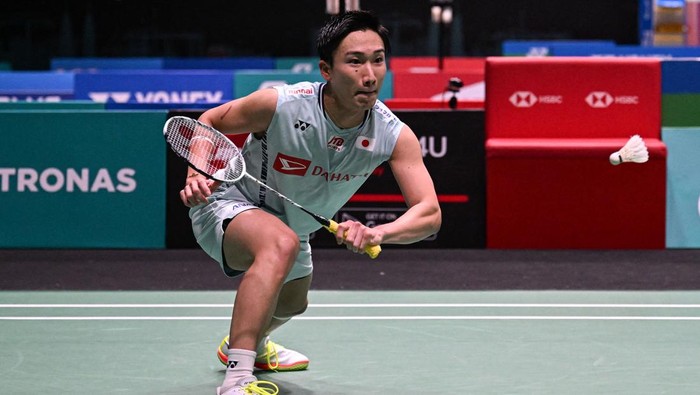 Cedera, Vito Keluar Axiata Arena dengan Kursi Roda Japan's Kento Momota (2nd L) gestures as he leaves the court after his opponent Indonesia's Rhustavito Shesar Hiren (R) retired due an injury during their mens singles quarter-final match at the Malaysia Open badminton tournament in Kuala Lumpur on July 1, 2022. (Photo by Mohd RASFAN / AFP) (Photo by MOHD RASFAN/AFP via Getty Images)