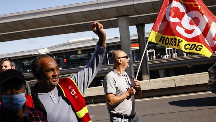 Unionists strikers demonstrate outside a terminal Friday, July 1, 2022 at Roissy airport, north of Paris. Flights from Charles de Gaulle airport in Paris and other French airports faced disruptions Friday as airport workers held a strike and protests to demand salary hikes to keep up with inflation. It's the latest trouble to hit global airports this summer, as travel resurges after two years of virus restrictions. (AP Photo/ Thomas Padilla)
