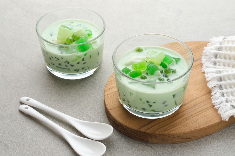 Buko Pandan, a dessert from Philippines, made from jelly, young coconut, evaporated milk, sweetened condensed milk, and ice. Served on glass. Selective focus.
