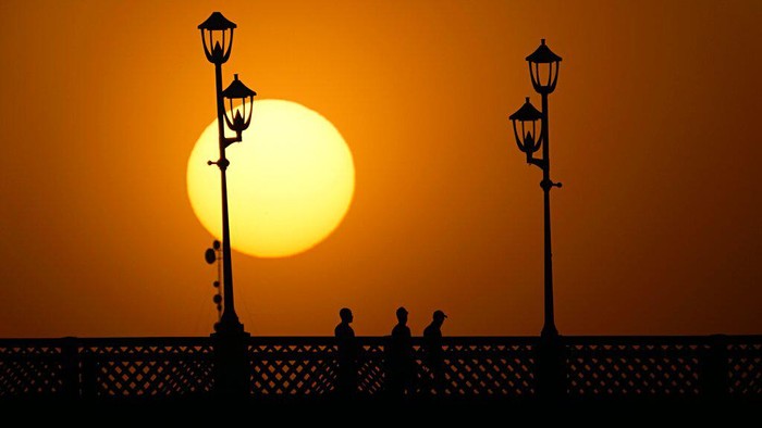 The sun sets behind Al-Ahrar bridge over the Tigris Rive in Baghdad, Iraq, Tuesday, June 28, 2022. (AP Photo/Hadi Mizban)