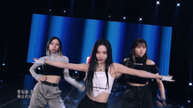 Meskipun terlihat seperti scarf, Karina aespa ternyata memakai face mask keluaran Alexander Wang sebagai atasannya. Dia memadukannya dengan cargo pants hitam dan sneakers yang cocok jadi outfit konser. Foto: dok. YouTube aespa