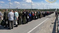 Tahanan berbaris di sepanjang jalan selama pertukaran tahanan, saat serangan Rusia di Ukraina berlanjut, dalam foto selebaran yang dirilis pada 29 Juni 2022.
