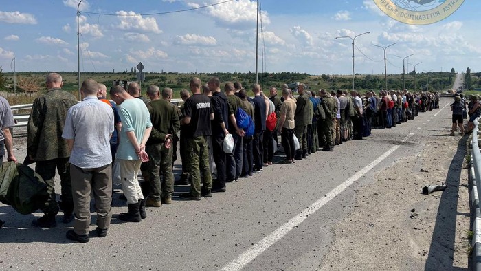 A man with a white flag walks along the road during an exchange of prisoners, as Russia's attack on Ukraine continues, at a location given as Zaporizhzhia region, Ukraine, in this handout photo released on June 29, 2022.   Courtesy of Ukraine's Military Intelligence/Handout via REUTERS    THIS IMAGE HAS BEEN SUPPLIED BY A THIRD PARTY. MANDATORY CREDIT. DO NOT OBSCURE LOGO. TPX IMAGES OF THE DAY
