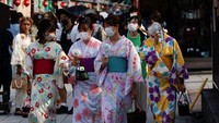 Wanita yang mengenakan kimono musim panas menggunakan kipas portabel saat mereka berjalan di jalan saat pemerintah Jepang mengeluarkan peringatan tentang kemungkinan pemadaman listrik akibat gelombang panas di distrik Asakusa di Tokyo, Jepang, Rabu, (29/6/2022).