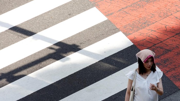 A woman wears a handkerchief on her head during a heatwave in Tokyo, Japan, June 27, 2022. REUTERS/Kim Kyung-Hoon